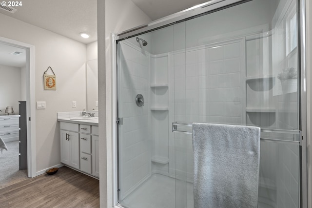 bathroom with vanity, hardwood / wood-style floors, and a shower with shower door