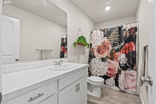 bathroom featuring curtained shower, wood-type flooring, toilet, and vanity