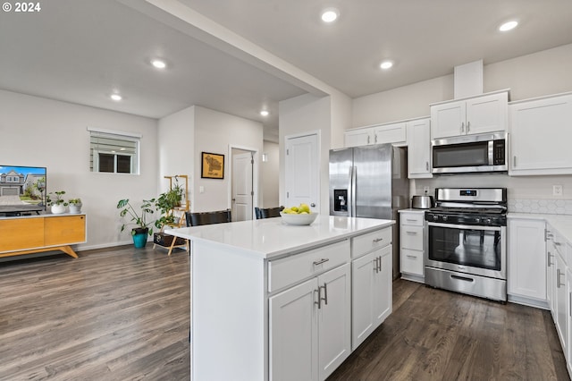 kitchen with white cabinetry, appliances with stainless steel finishes, dark hardwood / wood-style flooring, and a kitchen island