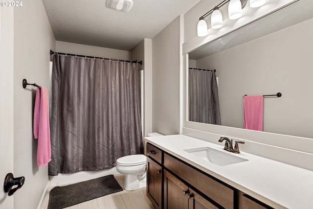 bathroom with vanity, toilet, wood-type flooring, and a textured ceiling