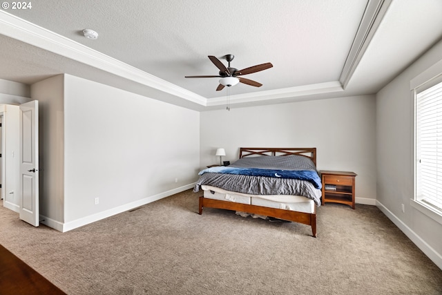 bedroom featuring carpet flooring, a textured ceiling, a raised ceiling, and ceiling fan