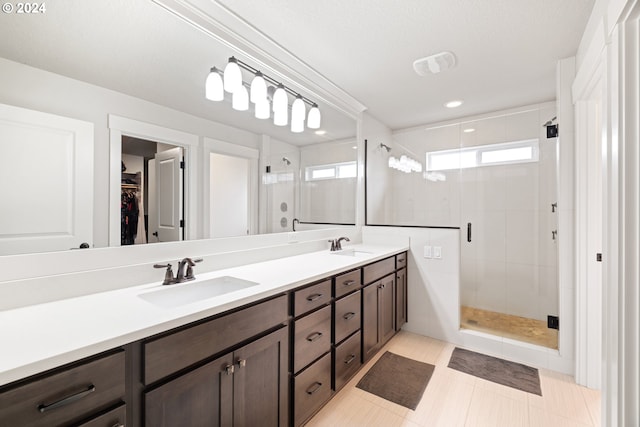 bathroom featuring a textured ceiling, tile patterned flooring, vanity, and an enclosed shower