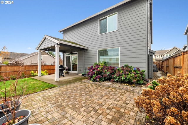 rear view of house featuring a patio and a lawn