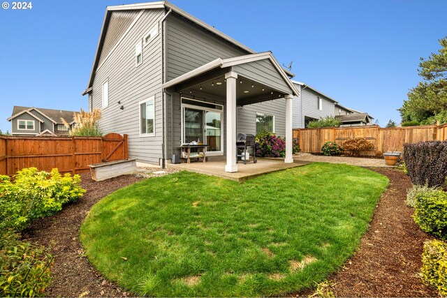 rear view of property with a patio and a lawn