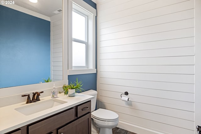 bathroom with a wealth of natural light, hardwood / wood-style floors, vanity, and toilet