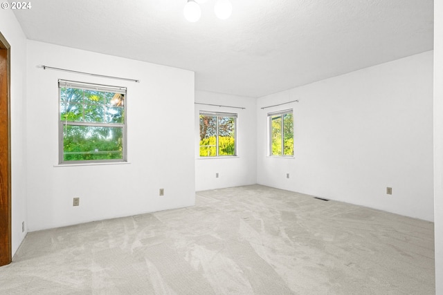 carpeted empty room featuring a textured ceiling