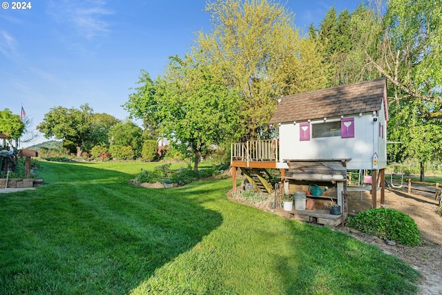 view of yard featuring a wooden deck and an outbuilding