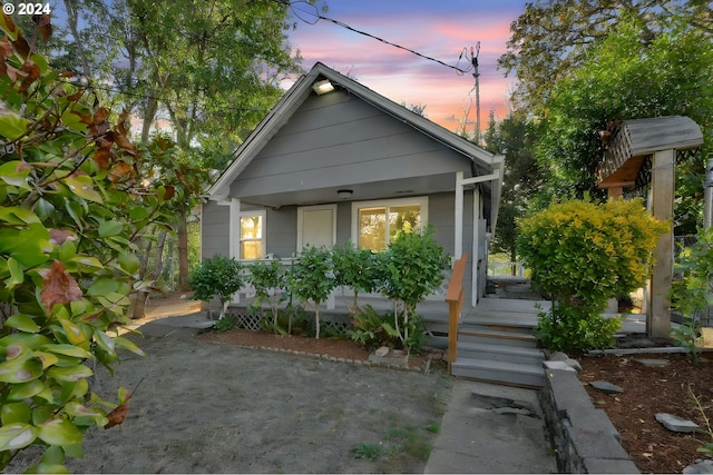 back house at dusk with covered porch