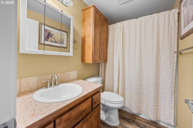 bathroom featuring toilet, curtained shower, vanity, and wood finished floors