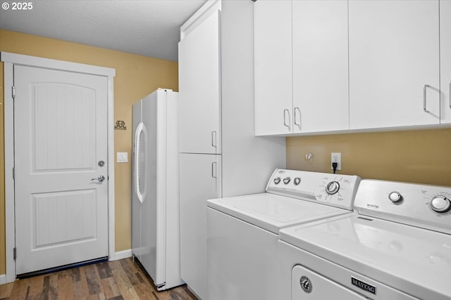 laundry room featuring cabinet space, washing machine and clothes dryer, baseboards, and dark wood-style floors