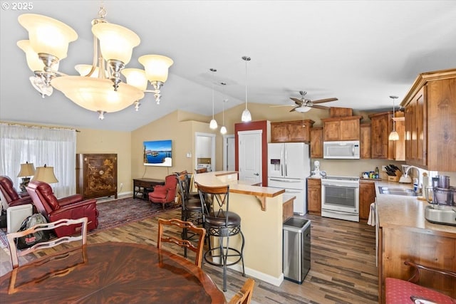 kitchen featuring brown cabinets, a sink, white appliances, lofted ceiling, and dark wood-style floors