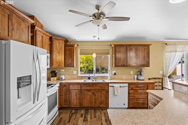 kitchen featuring light countertops, a ceiling fan, a sink, and white appliances
