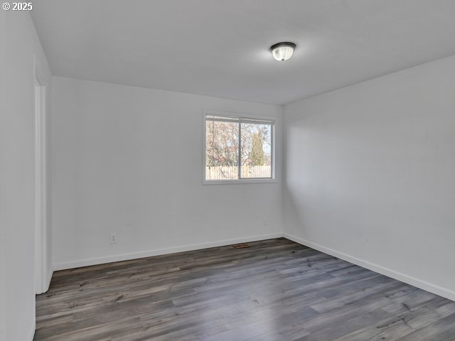 spare room featuring dark wood-type flooring