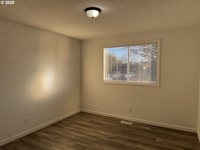 unfurnished room featuring dark wood-type flooring