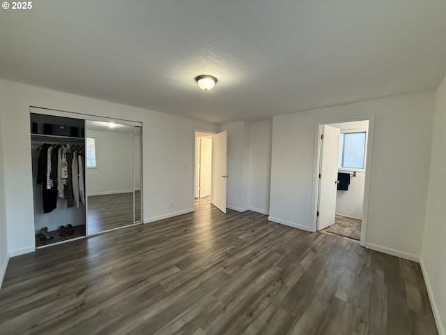 unfurnished bedroom with dark wood-type flooring, a closet, and a textured ceiling