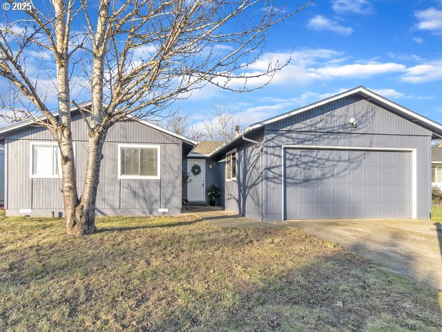 single story home featuring a garage and a front lawn