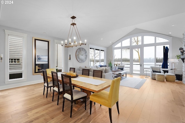 dining space featuring a notable chandelier, lofted ceiling, and light hardwood / wood-style floors