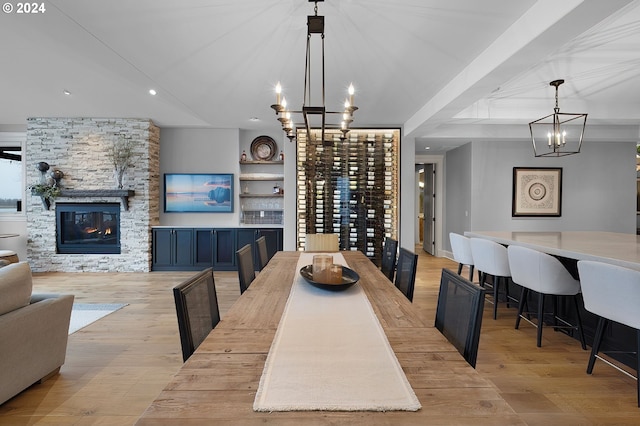 dining space featuring a chandelier, light hardwood / wood-style floors, and a fireplace