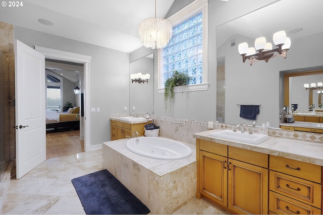 bathroom featuring a relaxing tiled tub, a chandelier, vaulted ceiling, and vanity