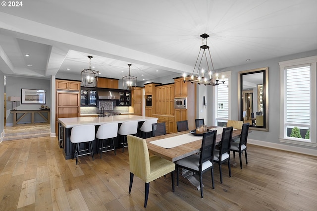 dining space featuring light wood-type flooring and a notable chandelier