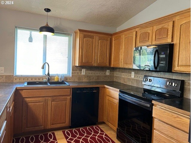 kitchen featuring backsplash, sink, black appliances, vaulted ceiling, and a textured ceiling