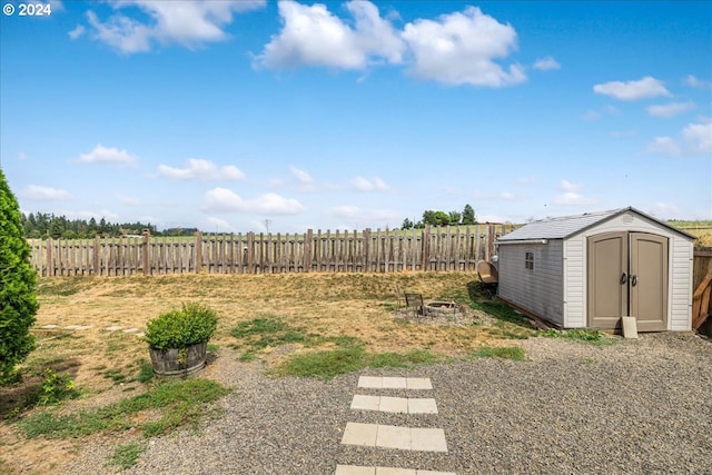 view of yard featuring an outdoor fire pit and a shed