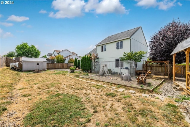 rear view of property with a storage unit and a lawn