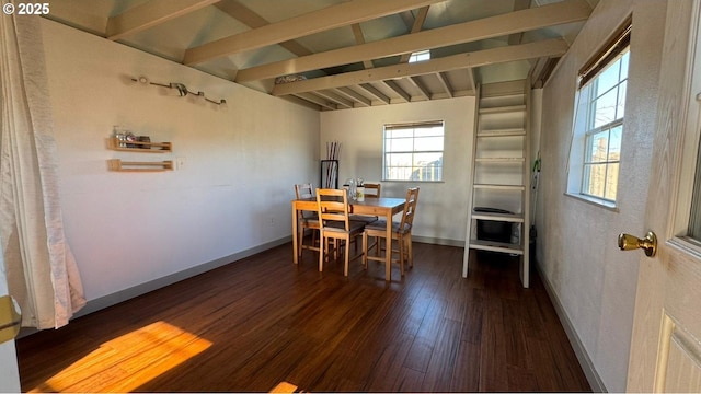 dining space with lofted ceiling with beams and dark hardwood / wood-style flooring