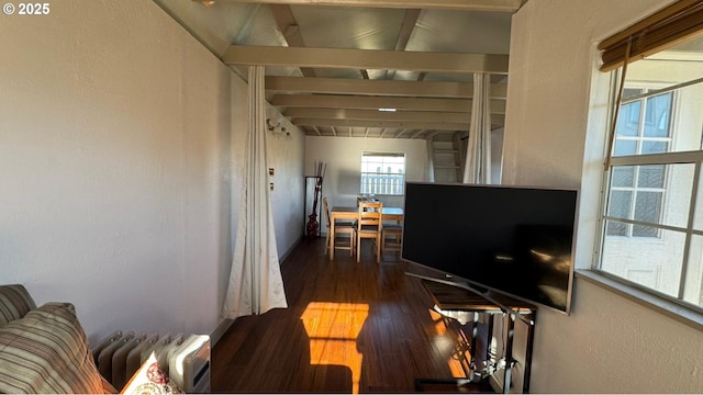 living room featuring hardwood / wood-style flooring, radiator, and vaulted ceiling with beams