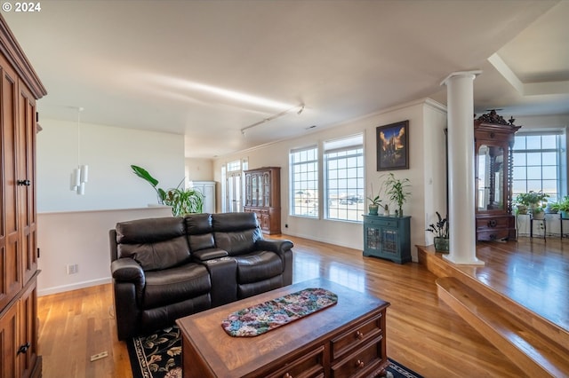 living room featuring decorative columns and light wood-type flooring