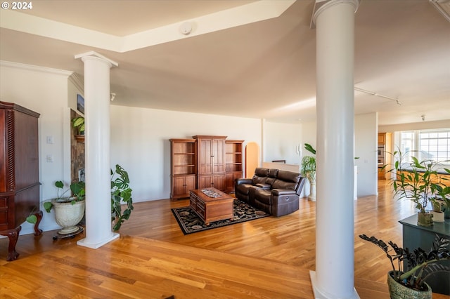 living area with track lighting, ornate columns, and wood finished floors