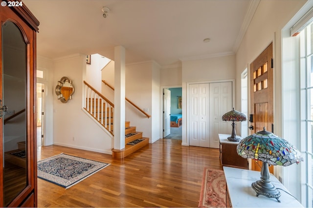 entrance foyer featuring ornamental molding and hardwood / wood-style floors