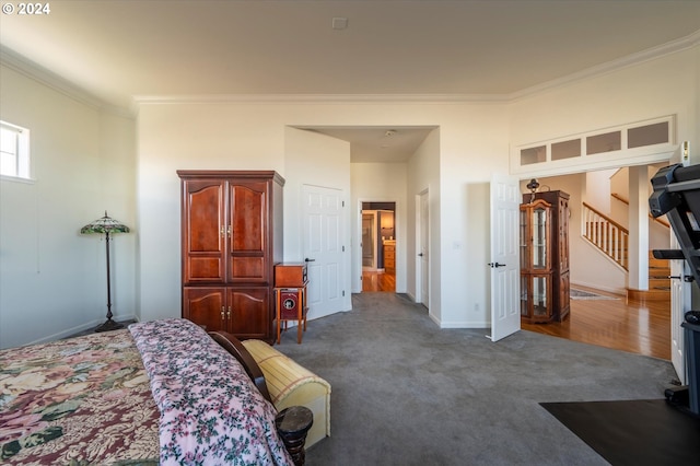 carpeted bedroom featuring crown molding and baseboards