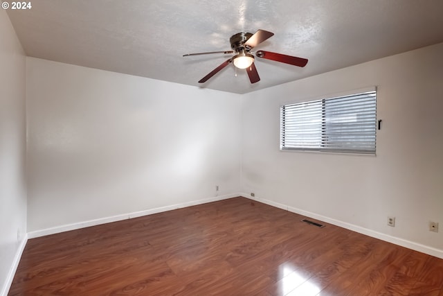 spare room with ceiling fan and dark wood-type flooring