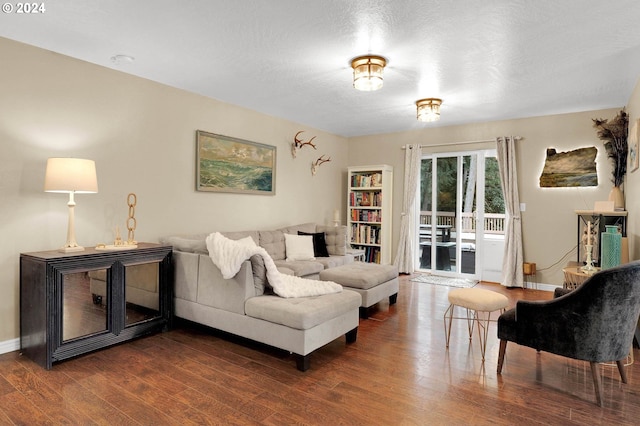 living room featuring dark wood-type flooring and a textured ceiling