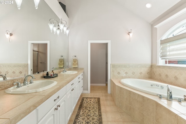 bathroom featuring tile patterned flooring, vanity, and tiled tub