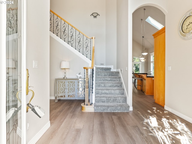 foyer entrance featuring hardwood / wood-style floors and a towering ceiling