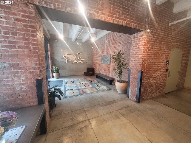 corridor featuring concrete flooring and brick wall