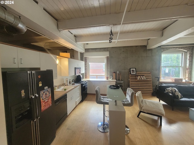 kitchen featuring black appliances, sink, light hardwood / wood-style flooring, beamed ceiling, and white cabinetry