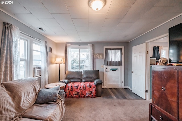 living room featuring cooling unit, carpet floors, and crown molding