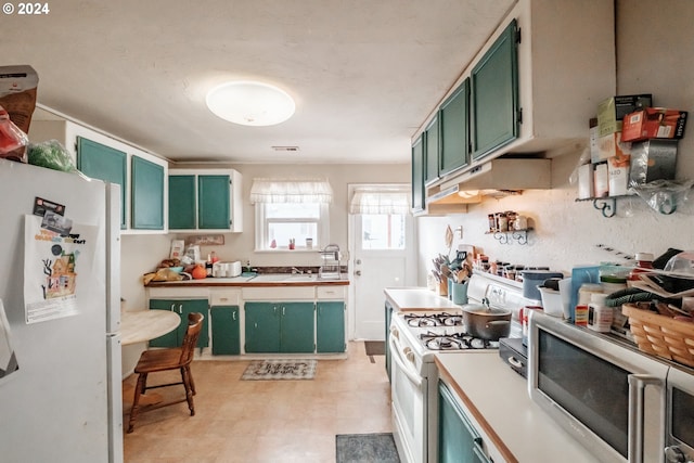 kitchen with white appliances, exhaust hood, and green cabinetry