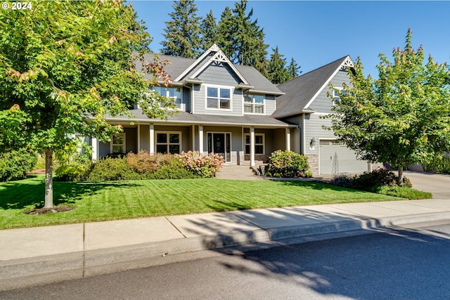 craftsman house with a garage, driveway, a front lawn, and stone siding