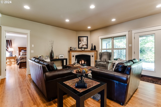 living area featuring a tile fireplace, light wood-style flooring, and recessed lighting