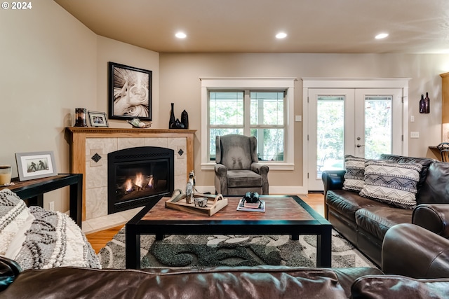 living area featuring recessed lighting, french doors, a fireplace, and light wood-style flooring