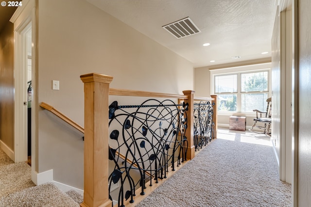 hallway featuring recessed lighting, visible vents, an upstairs landing, baseboards, and carpet