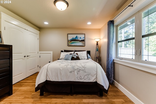 bedroom featuring a closet, recessed lighting, light wood-style flooring, and baseboards