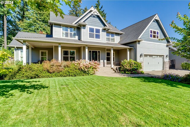 craftsman inspired home with a front yard, a garage, and a porch