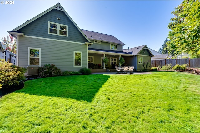 back of property with cooling unit, fence, a lawn, and a patio