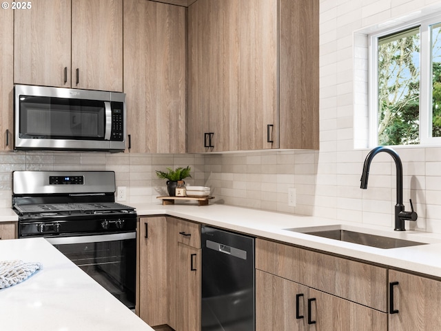 kitchen featuring a sink, light countertops, backsplash, and stainless steel appliances