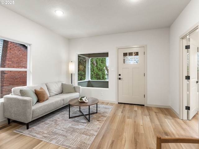 living area featuring light wood finished floors, visible vents, and baseboards